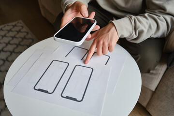 Designer is developing a UX mobile application wireframe. Sketch, prototype, framework, layout future app design for smartphone. UI/UX - user interface and user experience designer. App development