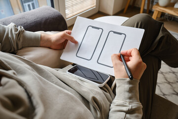 Designer is developing a UX mobile application wireframe. Sketch, prototype, framework, layout future app design for smartphone. UI/UX - user interface and user experience designer. App development