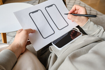 Designer is developing a UX mobile application wireframe. Sketch, prototype, framework, layout future app design for smartphone. UI/UX - user interface and user experience designer. App development