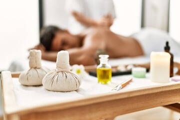 Poster - Young hispanic man relaxed having back massage at beauty center