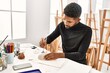 © Krakenimages.com - Young african american artist man concentrated painting pottery at art studio.