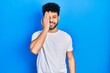 © Krakenimages.com - Young arab man with beard wearing casual white t shirt covering one eye with hand, confident smile on face and surprise emotion.