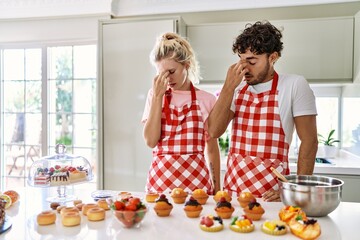 Sticker - Couple of wife and husband cooking pastries at the kitchen tired rubbing nose and eyes feeling fatigue and headache. stress and frustration concept.