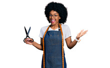 Young African American Woman Dressmaker Designer Wearing Atelier Apron Holding Scissors Celebrating Achievement With Happy Smile And Winner Expression With Raised Hand