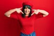 © Krakenimages.com - Young hispanic woman wearing french look with beret looking confident with smile on face, pointing oneself with fingers proud and happy.