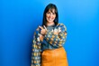 © Krakenimages.com - Young hispanic woman wearing casual winter sweater cheerful with a smile of face pointing with hand and finger up to the side with happy and natural expression on face