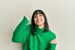 © Krakenimages.com - Young hispanic woman wearing casual winter sweater screaming proud, celebrating victory and success very excited with raised arms