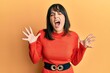 © Krakenimages.com - Young hispanic woman wearing casual clothes celebrating mad and crazy for success with arms raised and closed eyes screaming excited. winner concept