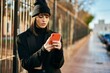 © Krakenimages.com - Young hispanic woman with serious expression using smartphone at the city.