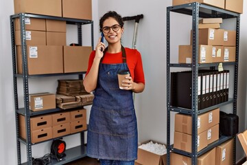 Wall Mural - Young latin woman ecommerce business worker talking on the smartphone at office