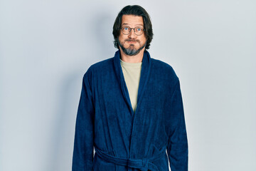 Canvas Print - Middle age caucasian man wearing bathrobe and glasses puffing cheeks with funny face. mouth inflated with air, crazy expression.