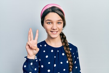 Wall Mural - Young brunette girl wearing elegant look showing and pointing up with fingers number three while smiling confident and happy.