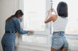 © kalinichenkod - young women make repairs in the apartment. Two girls make repairs at home on their own