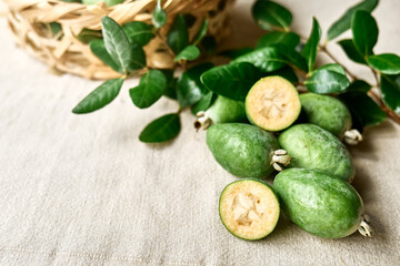 Wall Mural - Fresh green feijoa fruits on linen tablecloth. Acca sellowiana berries of the guava family. Vitamin C, Healthy eating. Selective focus.