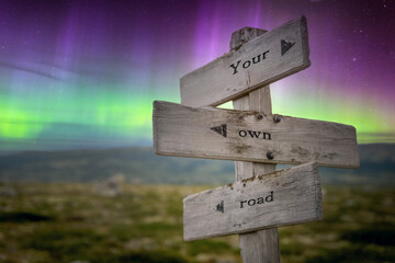 Wall Mural - your own road text quote on wooden signpost outdoors in nature with northern lights above.
