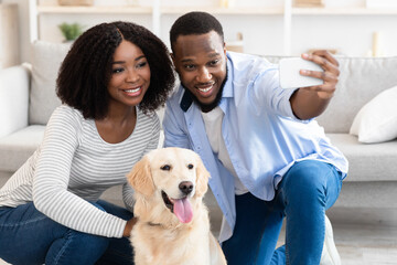 Wall Mural - Young black couple taking selfie with pet at home