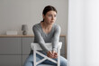 Leinwandbild Motiv Worried anxiety unhappy pretty caucasian millennial woman sitting on chair and looking out the window