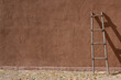 New Mexico adobe wall with ladder resting againt it