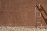 Fototapeta Sport - New Mexico adobe wall with ladder resting againt it