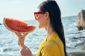 Wall Mural - cheerful woman near the ocean with watermelon posing