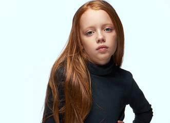 Wall Mural - red-haired girl in a black sweater planning close-up