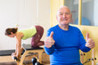 Portrait of an elderly senior citizen in a rehab room doing pilates