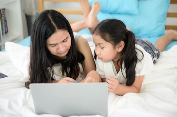 child girl person 2 sisters watching media and learning on laptop, online communication at home