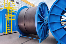 Large Diameter Cable Reels. Power Cables On Metal Coil. Concept - Production Of Electrical Wires. Reel For Installing Power Cable. Electric Wires Are Kept Outdoors. Power Wire Manufacturing