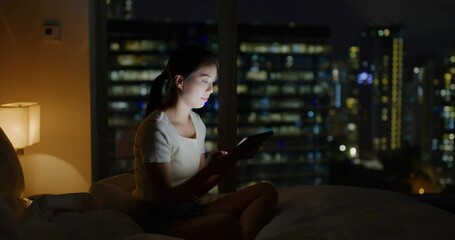 Wall Mural - Woman use tablet computer on bed inside living room at night