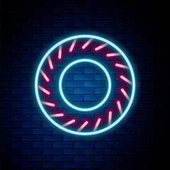 Sticker - Glowing neon line Car tire icon isolated on brick wall background. Colorful outline concept. Vector