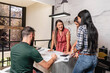 © STOCKEROcr - Grupo de profesionales sentados analizando planos constructivos e imágenes de un proyecto