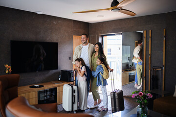 Wall Mural - Happy young family with two children enetring room at luxury hotel, summer holiday.