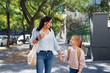 © Halfpoint - Happy grandmother taking granddaughter home from school, walking outdoors in street.