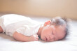 © Thannaree - Asian baby sleeping on gray bed