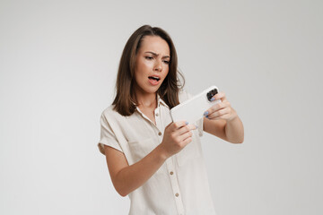 Wall Mural - Young european woman playing video game on cellphone