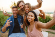 © Drobot Dean - Multiracial two couples taking selfie while leaning on trailer