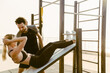 Young man and woman working out together on sports ground
