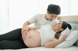 © u photostock - portrait asia young pregnant woman and husband happy together on the bed