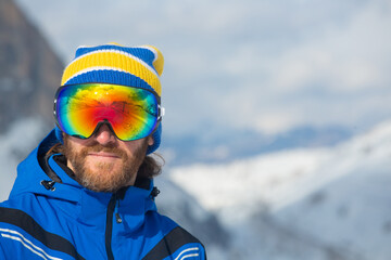 Wall Mural - Skier in goggles look at mountains