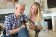 © goodluz - Happy couple with dog relaxing at home, sitting on carpet