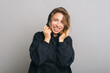 © Vulp - A happy woman is enjoying the coziness in her hoodie smiling and looking at the camera