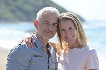 Middle-aged couple walking on a sandy beach