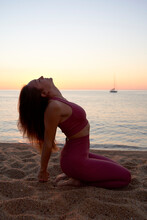 Sportswoman With Head Back Practicing Yoga At Beach