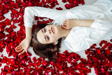 Beautiful Woman Lies In The Petals Of A Red Rose