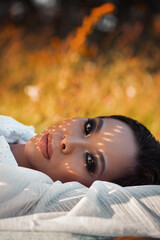 Wall Mural - Portrait young woman lying on grass