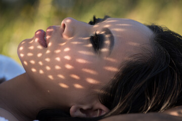 Wall Mural - Portrait young woman lying on grass