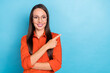 © deagreez - Photo of pretty cute young woman wear red shirt spectacles smiling pointing finger empty space isolated blue color background