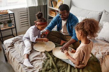 Canvas Print - High angle portrait of two little girls putting makeup on father while playing beauty salon