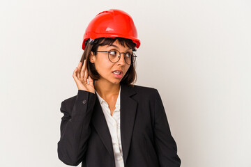 Young architect woman with red helmet isolated on white background trying to listening a gossip.