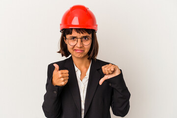 Wall Mural - Young architect woman with red helmet isolated on white background showing thumbs up and thumbs down, difficult choose concept